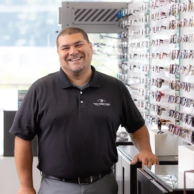 Scott Howard smiling next to a wall of glasses.